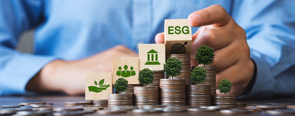 Geschäftsmann mit Münzen und Schriftzug ESG und Bäumen
